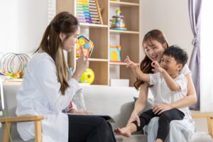 Therapist playing with mother and son during an aba therapy evaluation.